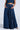 Styled in a long, flowing dark denim skirt with hands in pockets, they exude an AKIRA Label vibe. Paired with a matching denim top against a plain background, they embrace the charm of CARRIE ULTRA WIDE LEG DENIM TROUSER aesthetics.