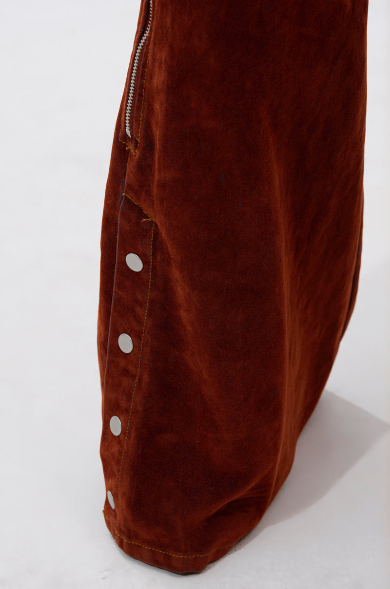 A close-up of the INCREDIBLE VELVET DENIM CHAPS in rust-colored suede Western style, showcasing silver snap buttons and a partial zipper detail against a plain white background.