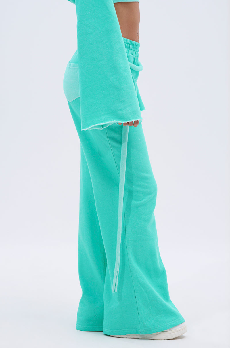 Person wearing ISSA Jogger Pant in Tiffany, a loose aqua-blue wide-leg jogger, paired with a matching long-sleeve top. The image shows the body from mid-torso down against a plain light background. 3