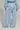 A person is wearing the HONEY HONEY WIDE LEG PANTS in light blue, featuring a high-rise design and matching padded jacket. This cotton blend knit outfit showcases soft fabric with pronounced seams running down the legs. The individual stands against a neutral background, facing away.