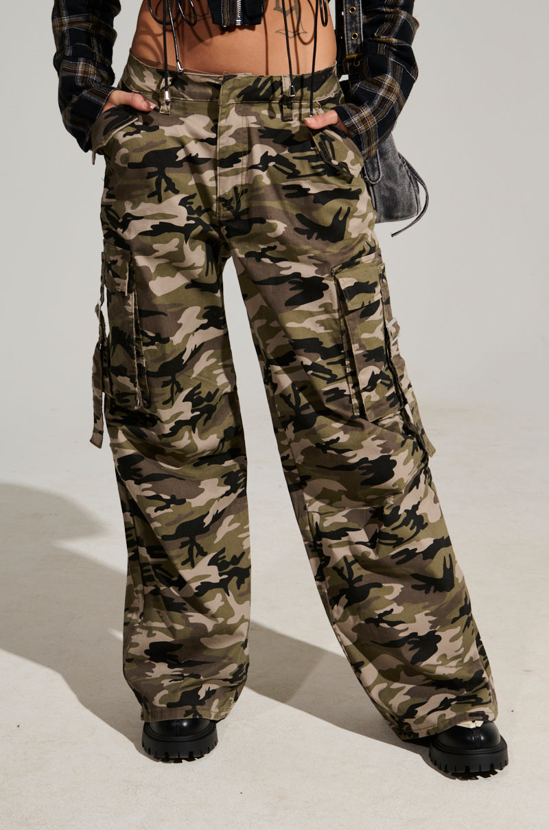 Person showcasing their street style with STREET STYLE WIDE LEG CAMO PANT and black boots against a neutral background.