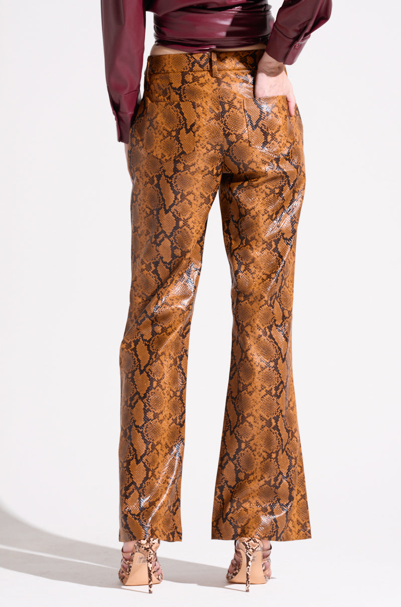 A person wearing SNAKESKIN STRAIGHT LEG TROUSER paired with a maroon top is standing with their back to the camera. They also have nude-colored high-heeled shoes on, set against a plain white background. 4