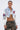 A woman in glasses and hoop earrings wears the OFF CAMPUS DENIM CROP BOMBER with faux leather sleeves over a white top and camo pants, standing against a plain light background.