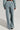 A person is seen from behind wearing the FREYA SWEATPANTS in a light blue-gray corduroy fabric paired with a matching top, highlighting the relaxed, wide-leg design similar to high-rise sweatpants. The simple light-colored backdrop enhances the AKIRA Label aesthetic.