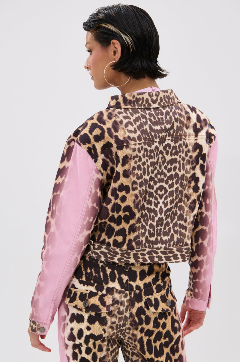 A person with short dark hair models the COCO LEOPARD PRINT DENIM JACKET, standing with their back turned and head slightly to the side against a plain background.