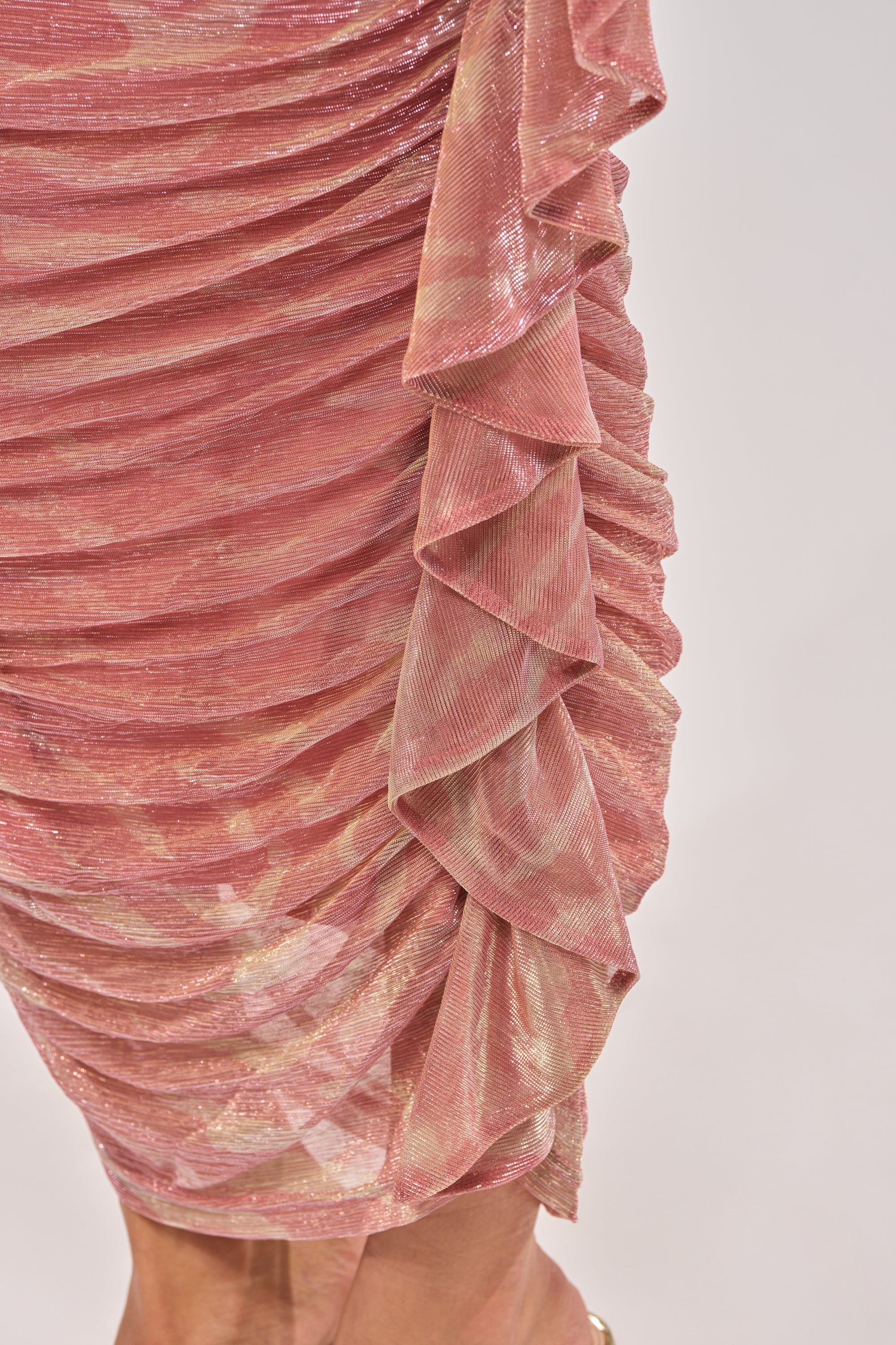 Close-up of the PLAY WITH ME MAXI SKIRT—pink, shimmery fabric with ruched, layered ruffles and a metallic sheen. The soft, slightly sheer material and textured drape make it perfect for vacation wear. 6