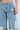 A person wearing ALL I'VE GOT Denim Bermuda Shorts in light blue, featuring distressed detailing and a detachable chain, stands against a plain background, showcasing the midsection and legs.