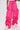 Someone wears the GIRL ON FIRE RUCHED JOGGER—bright pink, high-waisted, wide-leg jogger pants—with white sneakers, standing against a plain light background.