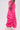 A person wearing the GIRL ON FIRE RUCHED JOGGER in hot pink and white sneakers stands sideways against a plain light background. Only the lower body is visible, highlighting the jogger's bold streetwear style.