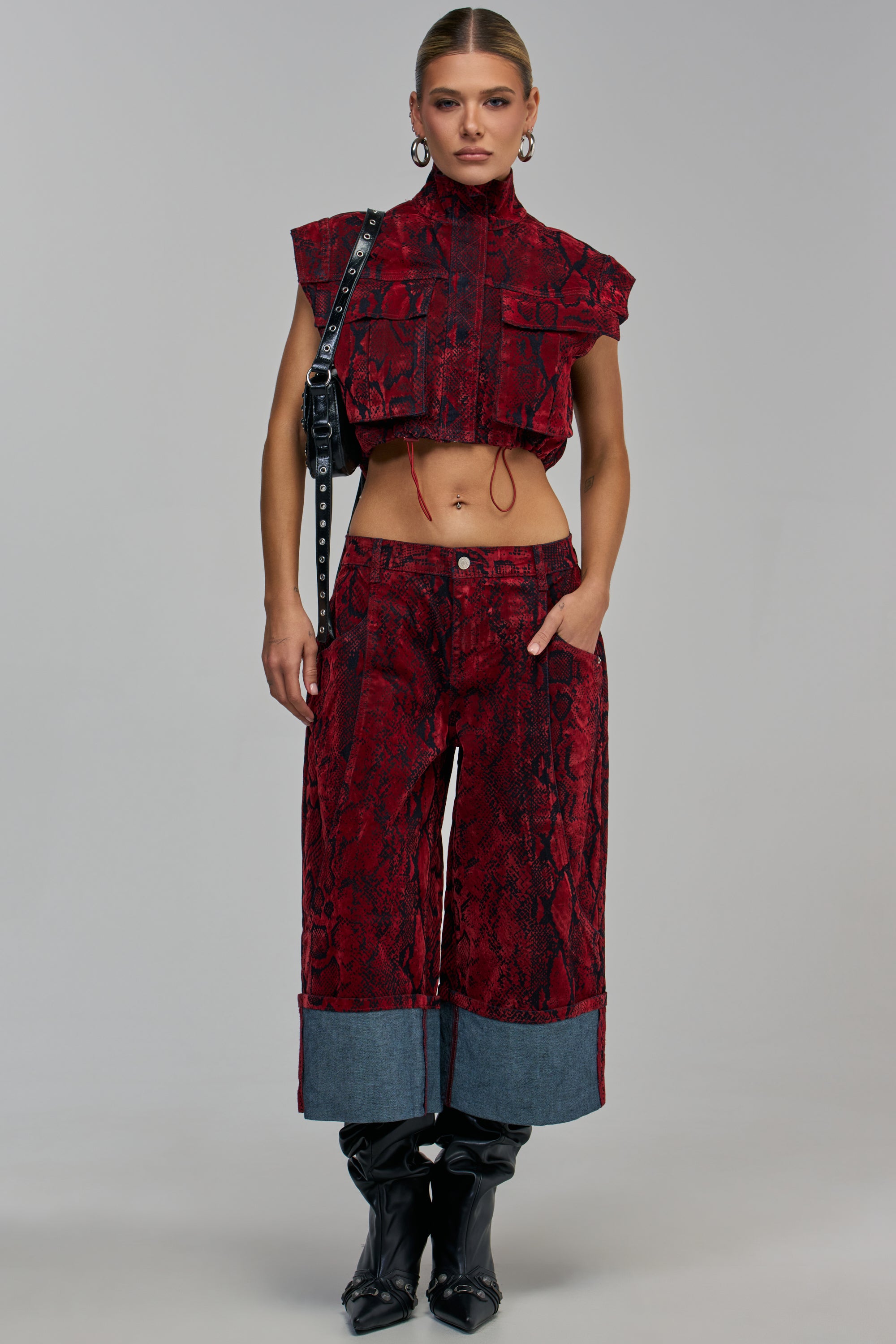 A model wears a red and black snakeskin-print cropped vest and matching TEXTURED TEMPTATION BERMUDA SHORT with wide denim cuffs.