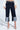 A person wears the LOCKED UP DENIM BERMUDA SHORT with a white textured blouse and cream pointed-toe heels. The dark denim shorts feature light patchwork at the wide-leg hems. Photo is cropped at the torso and below the knees.