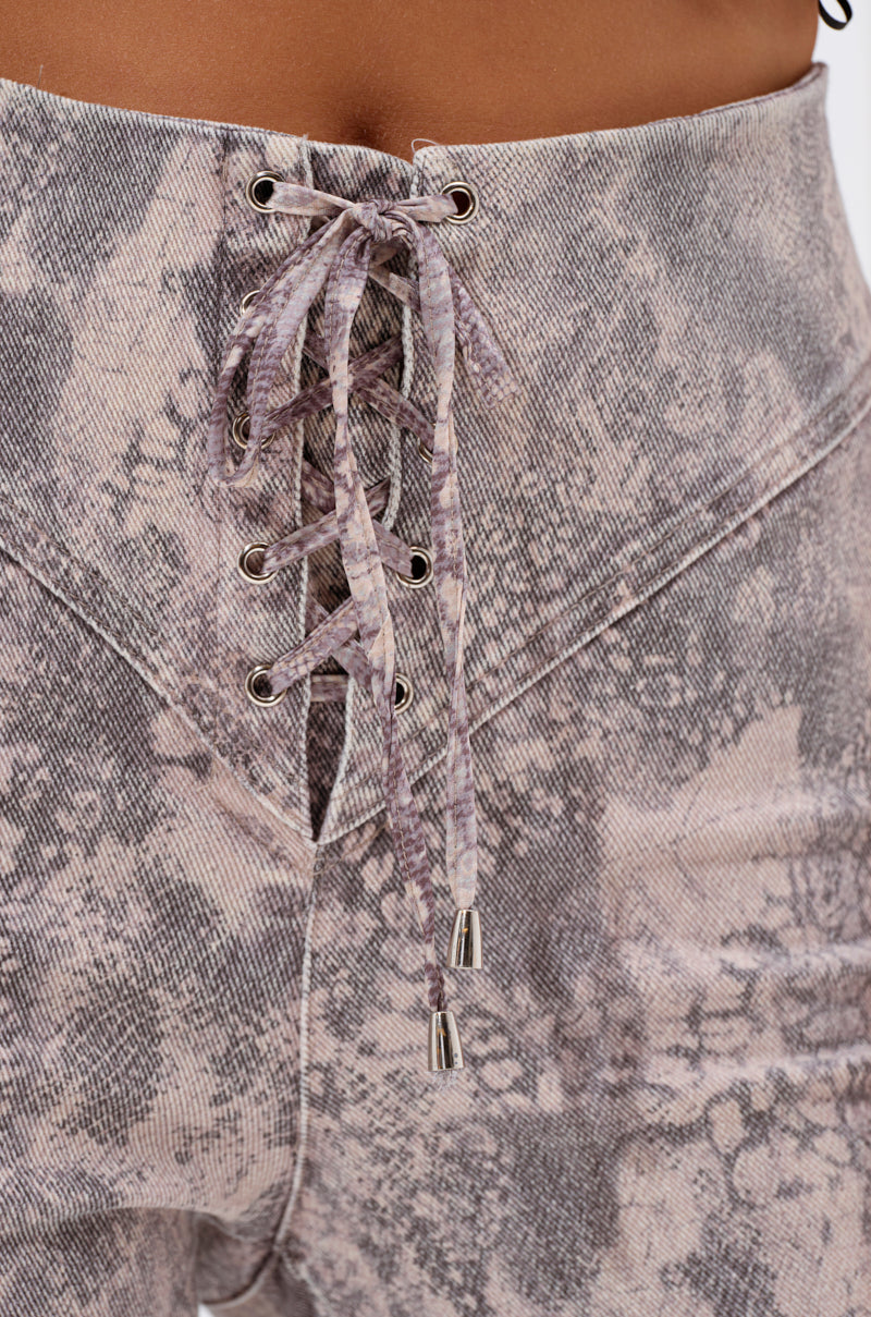 Close-up of the IN THE SUN SNAKE LACE-UP PANT featuring a high-rise fit, bold snakeskin pattern, metal eyelets, and silver-tipped drawstrings. 8