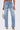 Wearing FEELING GRATEFUL RHINESTONE RELAXED DENIM—high-rise relaxed jeans with silver studs, cross patches, rhinestone embellishments, and distressed details—styled with heeled sandals and a silver handbag.
