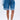 A person wears GONE BAD DENIM BERMUDA SHORTS with a light blue denim shirt and white lace-up sandals, standing against a plain light background.