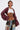 A person with short dark hair and torso tattoos, including an eye and 