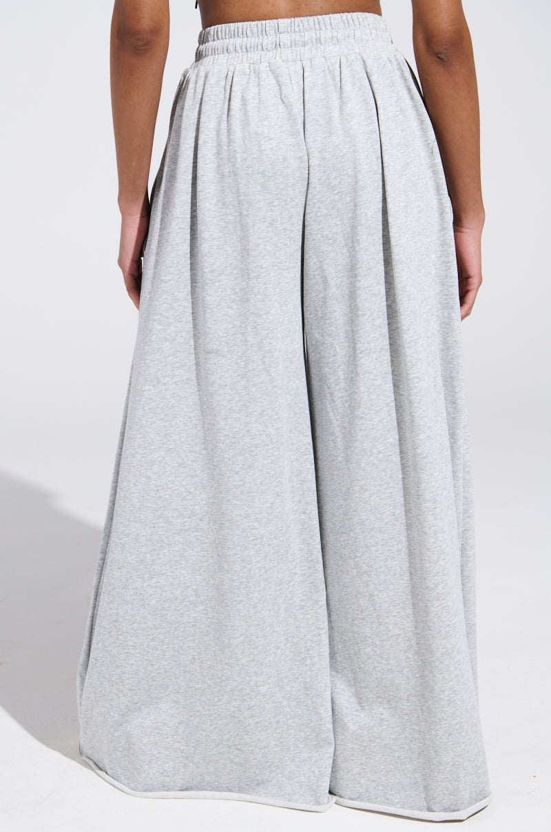 A person wears the COZY AND COMFY SWEATPANT in light gray, showcasing a high-rise, wide-leg design from the back against a plain background.
