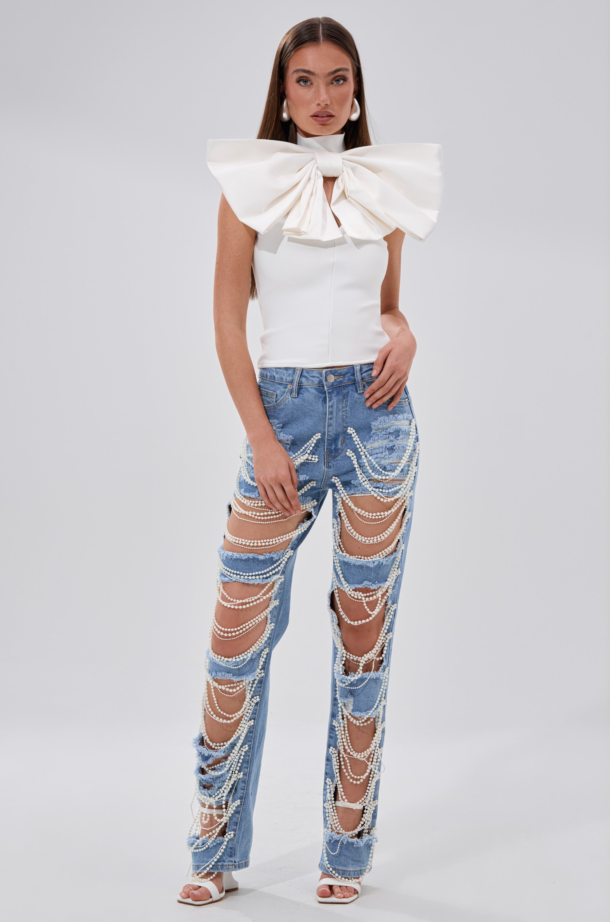 A woman wearing a white shirt and DISTRESSED LIFE DENIM PANT.