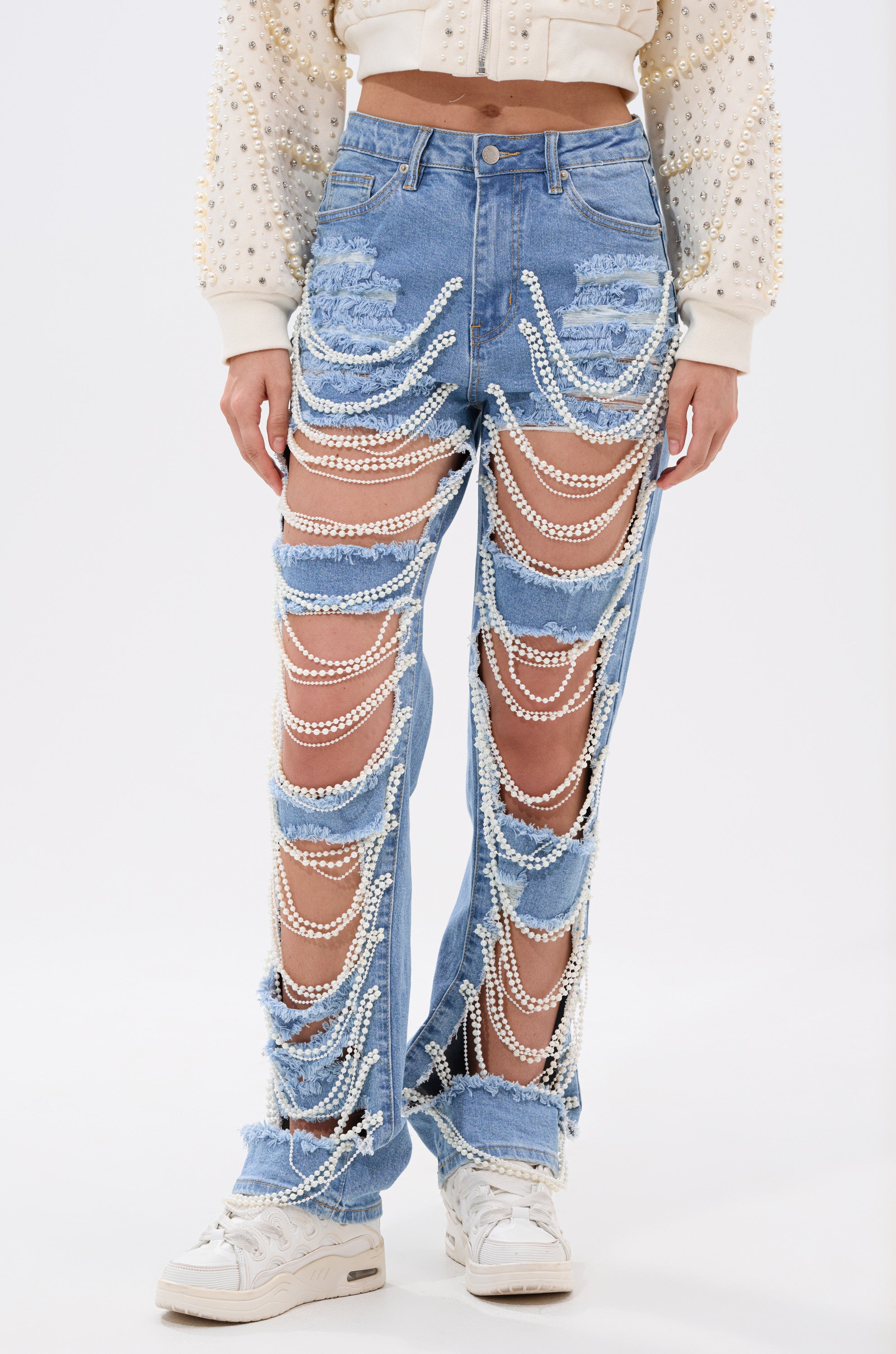 A person wearing the DISTRESSED LIFE DENIM PANT, featuring pearl embellishments and a high-rise straight leg fit.