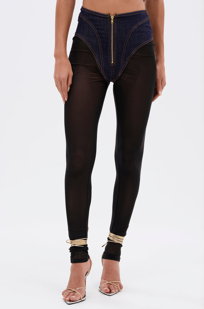 Someone models the ZIP ME UP MESH LEGGING WITH DENIM PANTY, featuring a high waist, mesh fabric, denim corset panel, and gold zipper, paired with gold strappy heels against a white background for an edgy streetwear vibe. 4