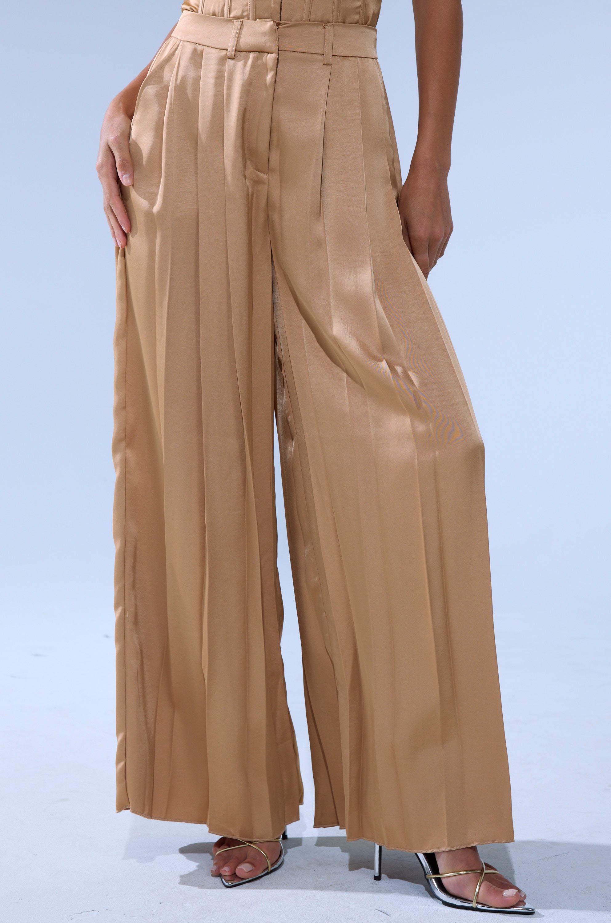 A person wearing HANSEL MOCHA SATIN PALAZZO PANT with silver open-toe heels stands against a plain light background.