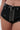 Close-up of a person wearing BABY PLZ FAUX LEATHER STUD HOT SHORT—high-rise black faux leather shorts with studs, grommets, zipper, and a decorative belt. A jeweled belly button piercing is visible.