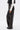Wearing the ROCK MY WORLD FAUX LEATHER LACE UP PANT—high-waisted black faux leather pants with silver eyelets and lace-up front and sides—styled with a black and white jacket and pointed black shoes.