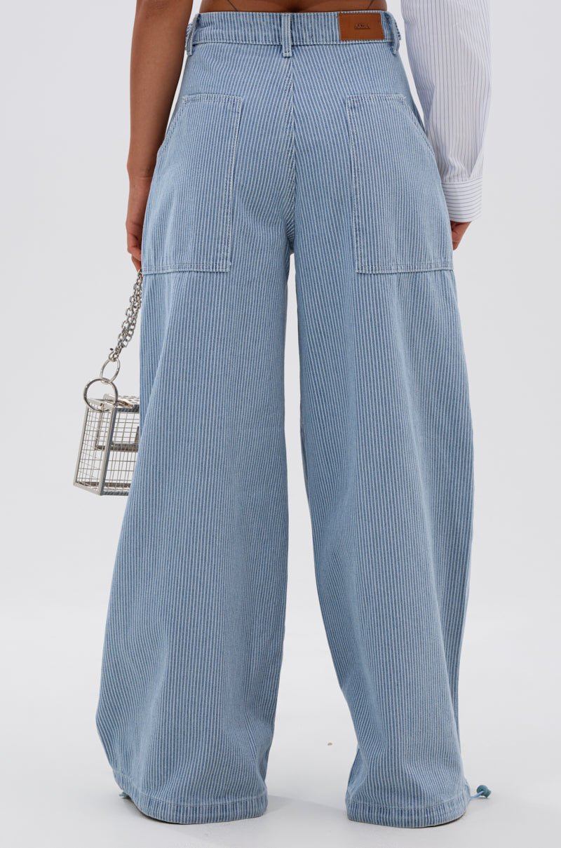 A person is shown from the back wearing SUMMERTIME BLUES STRIPE WIDE LEG DENIM jeans and holding a small, metallic cage-style handbag. 5