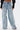 Wearing the WHO KNOWS DISTRESSED WIDE LEG DENIM, featuring vintage-inspired high-waisted style, vertical distressed seams, and frayed edges. Only the lower torso and legs are visible.