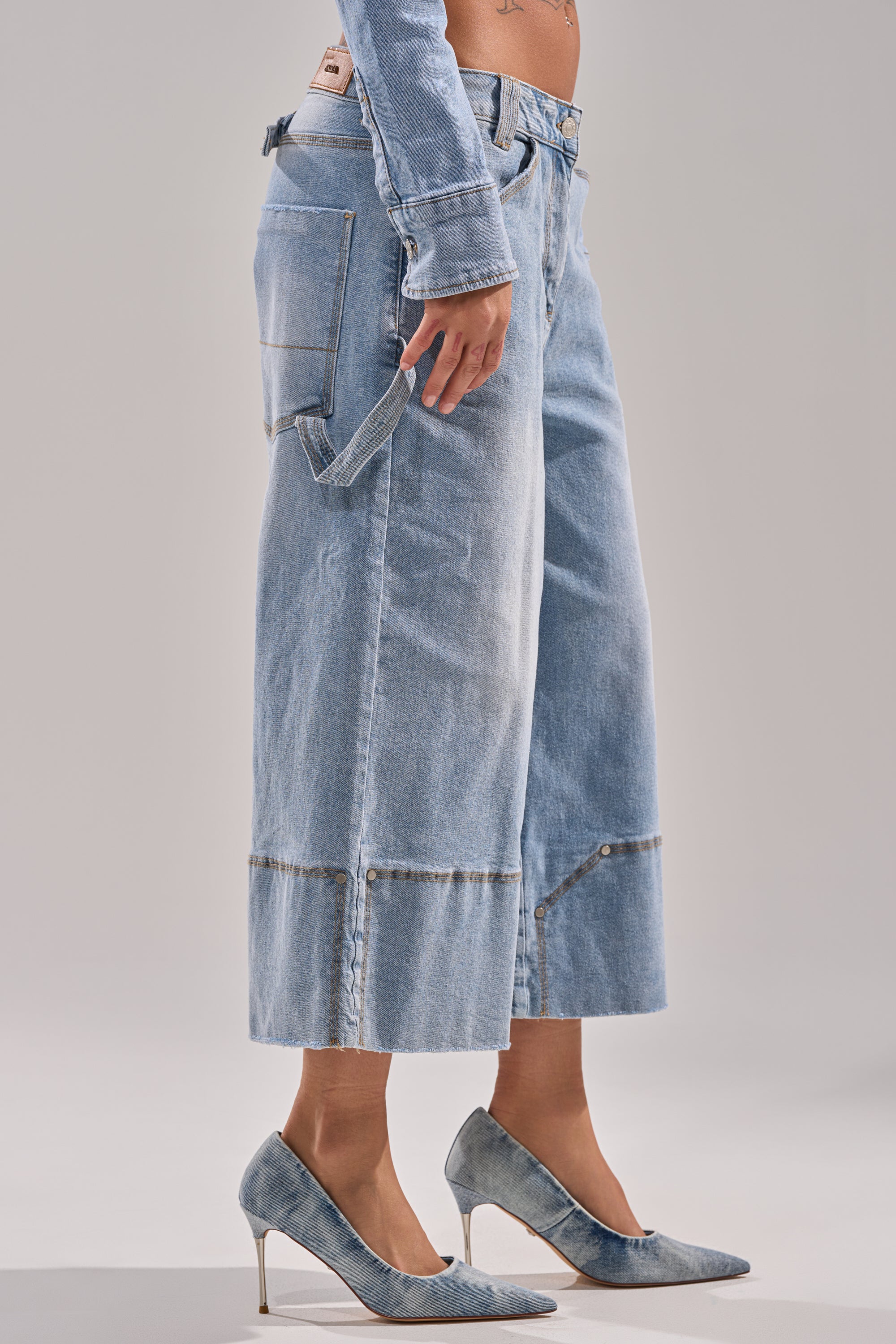 A person wears ROCK MY WORLD WIDE-LEG DENIM BERMUDA SHORTS in light blue with matching denim heels in a neutral studio, showing only their lower body.