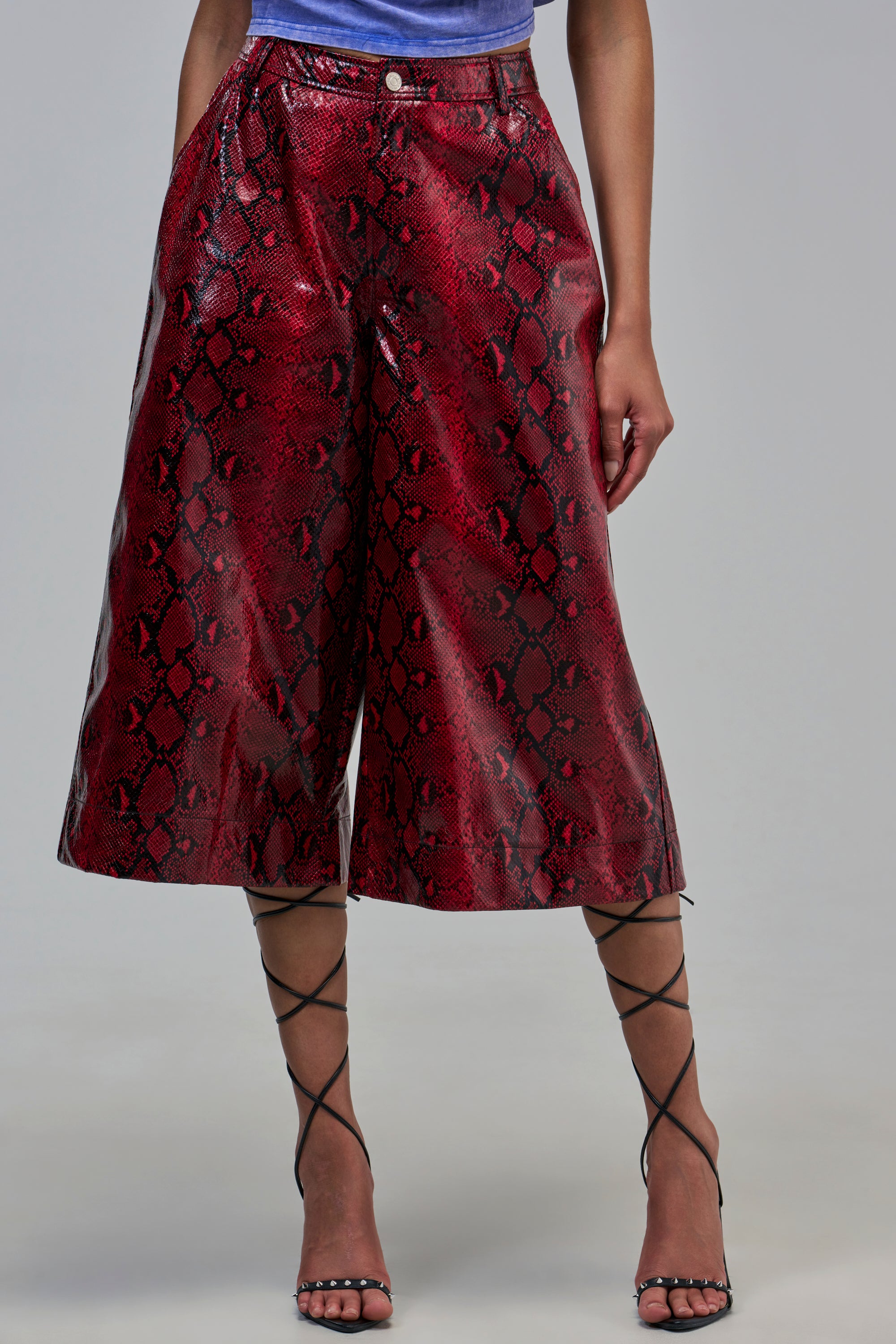 Red EXTRA IS MY MIDDLE NAME SNAKE BERMUDA SHORT with a high waist, paired with black lace-up heels.