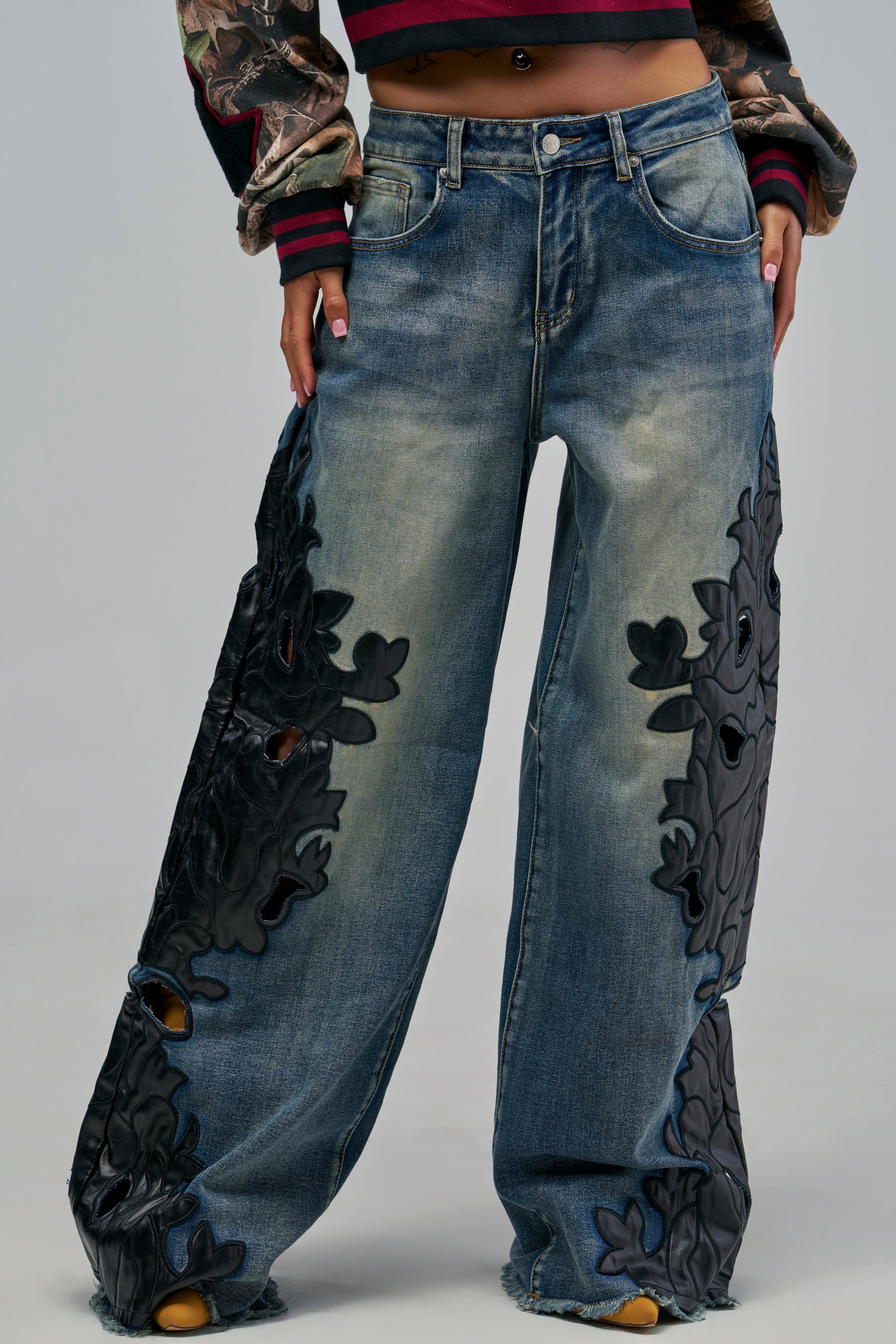 AMIGAS PU PRINT WIDE LEG DENIM wide-leg, medium wash blue jeans featuring black cut-out floral appliqué panels down the sides.