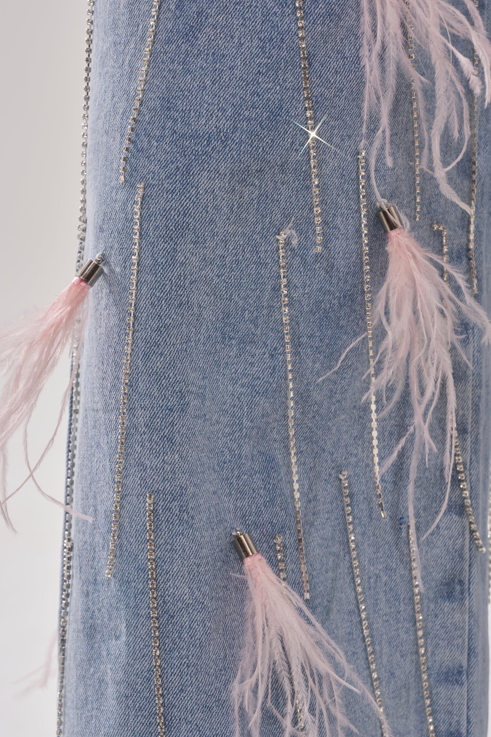 SHAKE IT FOR ME GIRL PINK FEATHER EMBELLISHED DENIM features light blue denim adorned with vertical silver chains and pink feather-inspired accents with metallic tips—ideal for adding standout flair to wide-leg styles. 7