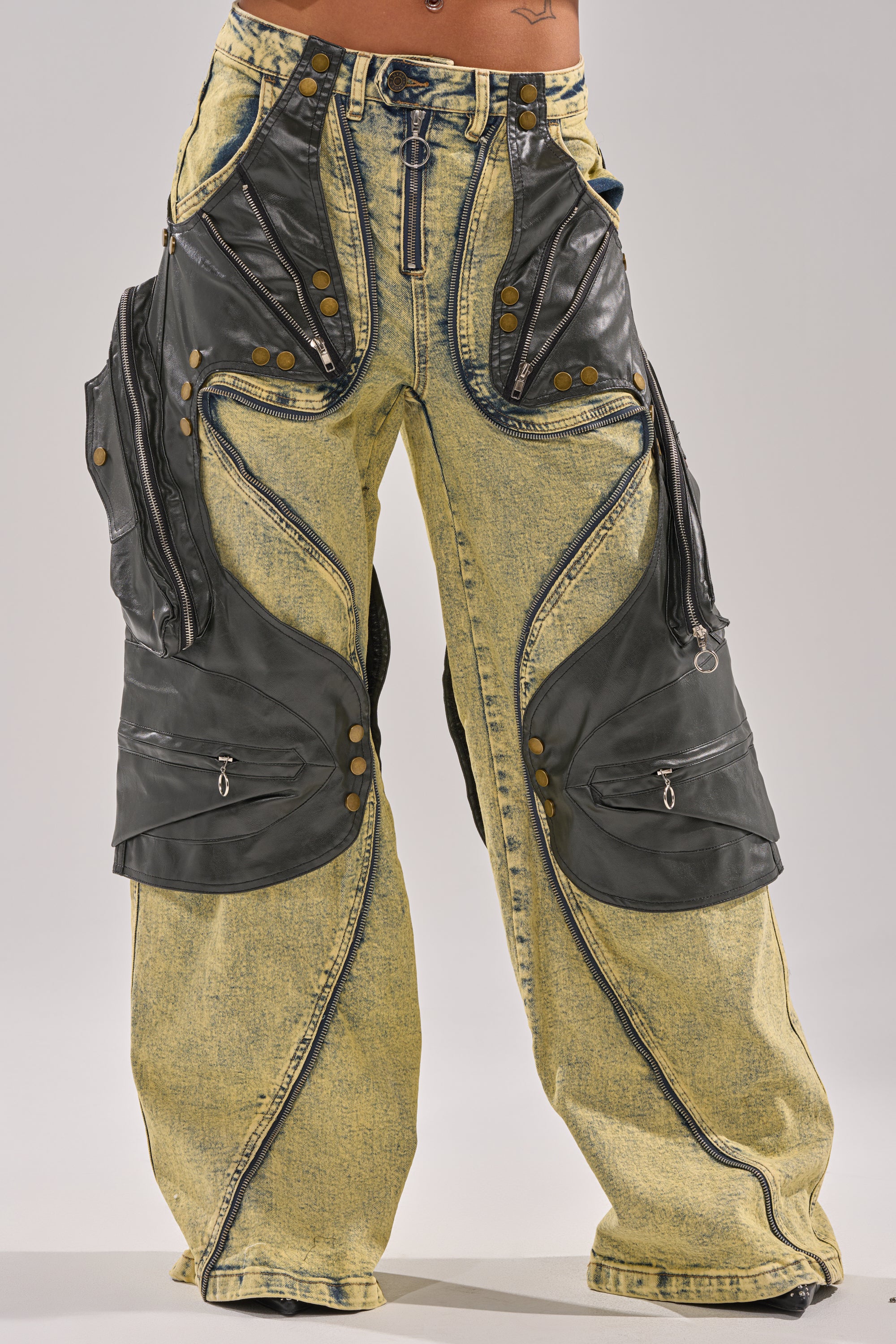 The CRAZY FOR YOU RELAXED DENIM features baggy yellow acid-wash jeans with faux leather panel detailing, zippers, rivets, decorative stitching, large side pockets, and bold asymmetrical accents for standout style. 1