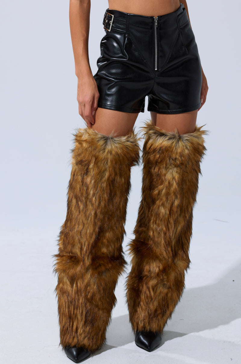 A person pairs furry boots with the BUILD ME UP FAUX LEATHER SHORT, creating a bold and stylish look. 3