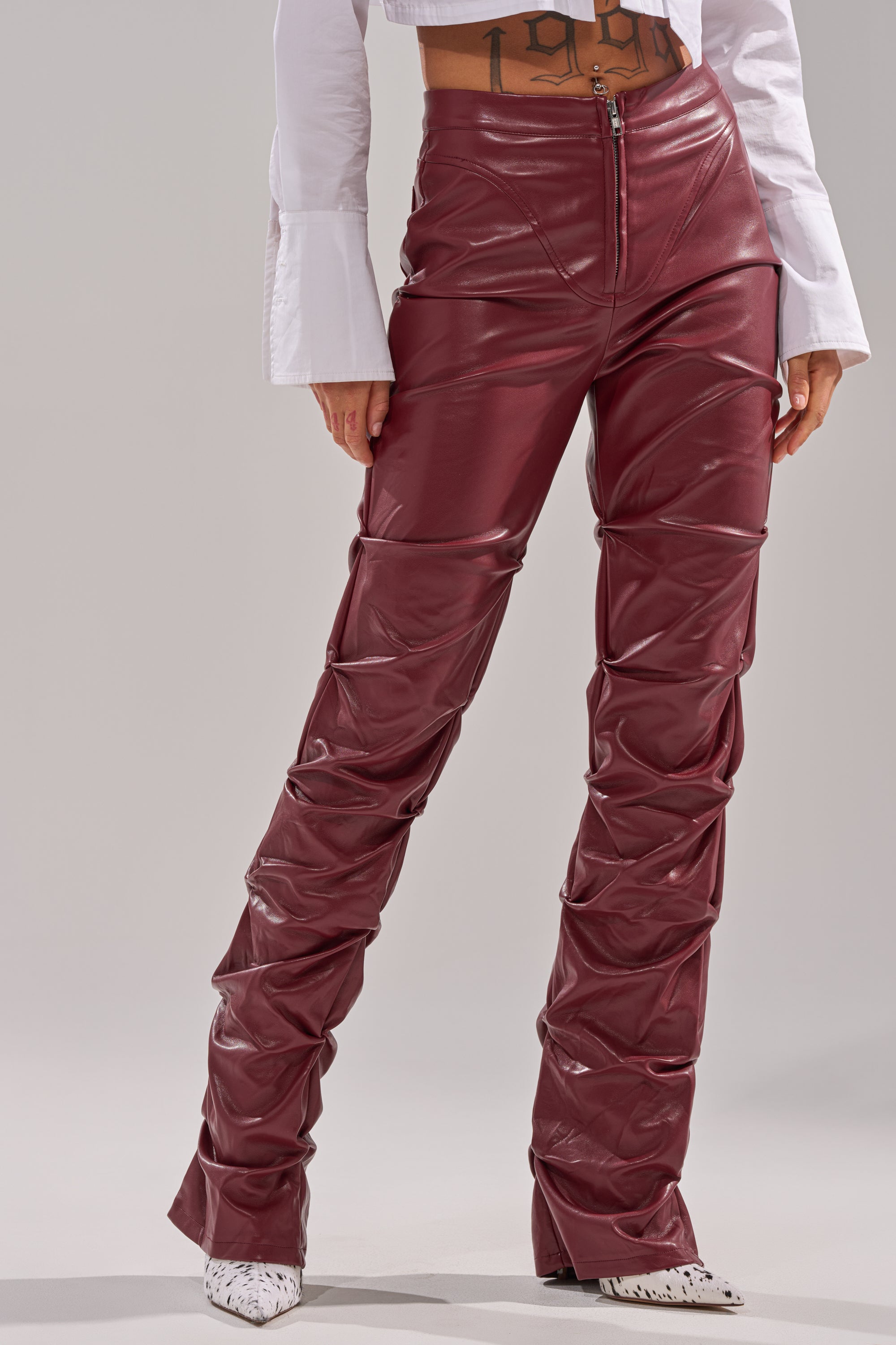 A woman wearing the DOWN AND DIRTY FAUX LEATHER PANT in burgundy. 2