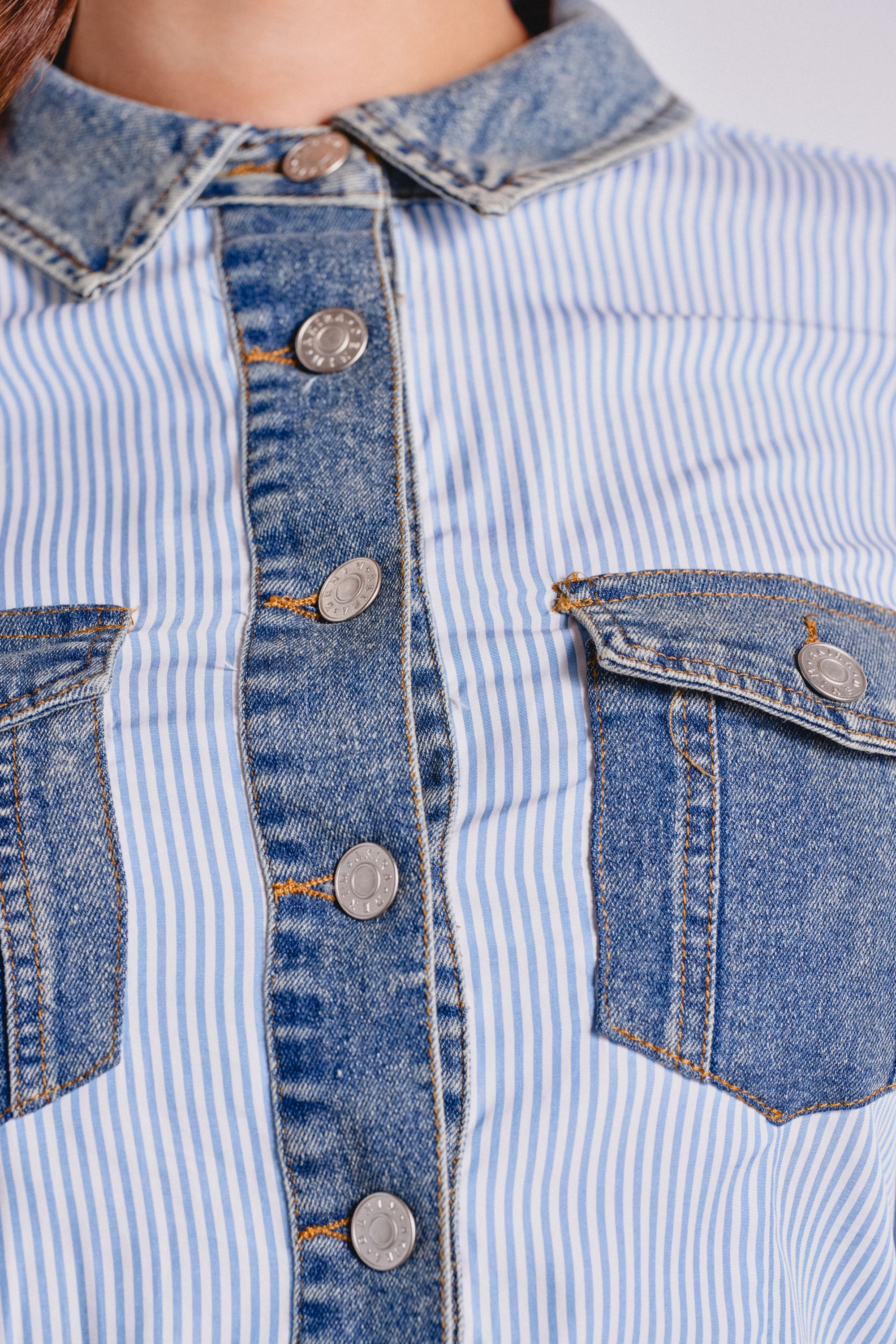 Close-up of a shirt with blue and white vertical stripes, denim trim, metal buttons, and two denim chest pockets—perfectly paired with EASY LOVER POPLIN SHORT for a coordinated summer look. 4