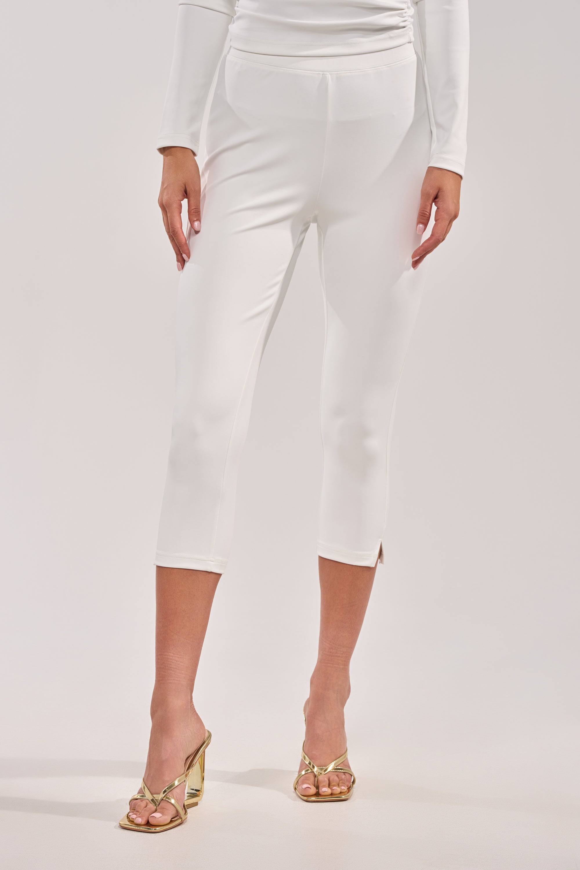 Wearing the MODEL OFF DUTY CAPRI with a matching long-sleeve top and gold open-toe heels, a person stands against a plain light background.