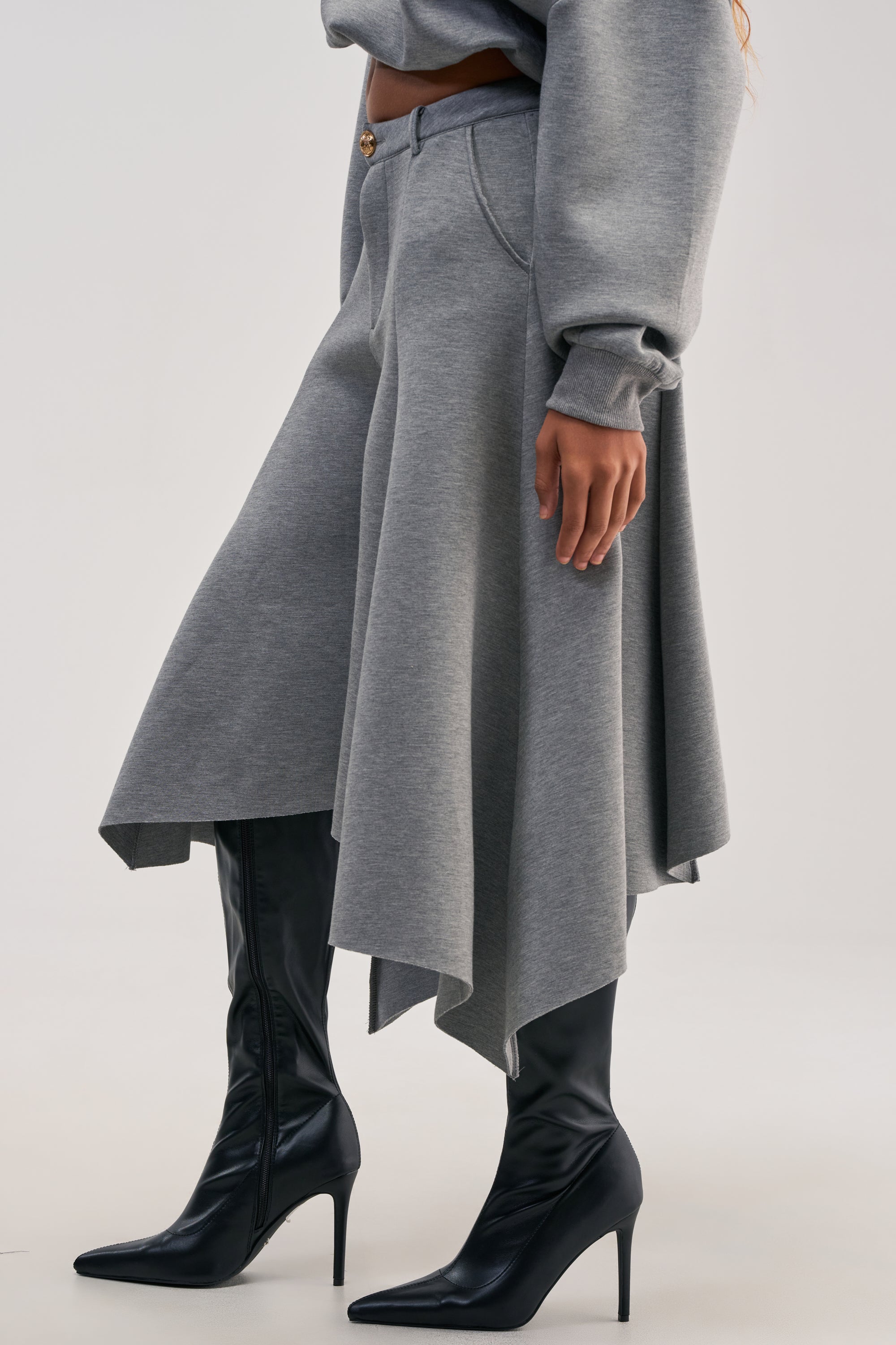 Person wearing WILD AND FREE CULOTTES in grey with a high-rise waistband, paired with a matching gray sweatshirt and black pointed-toe heeled boots. Only the lower half of the outfit is visible against a plain background.