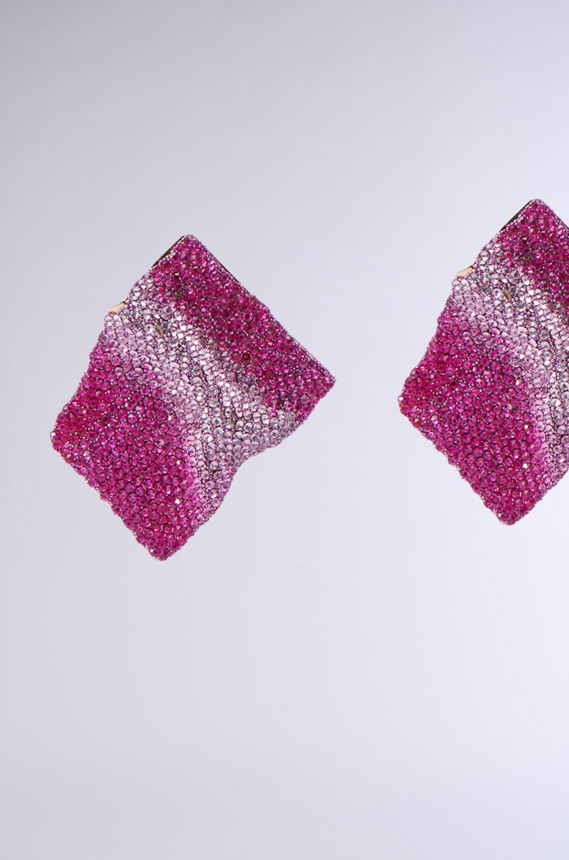 Two sparkling ITS MY WORLD BLING EARRINGS showcasing a diamond-shaped design, with a gradient of pink and silver hues accented by rhinestone embellishments, beautifully set against a plain gray background.