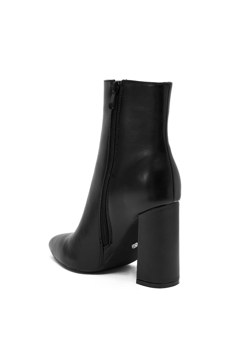 The AZALEA WANG JESSABELL BLACK CHUNKY BOOTIE features a side zipper, block heel, and smooth leather finish, shown from a rear side angle against a white background.