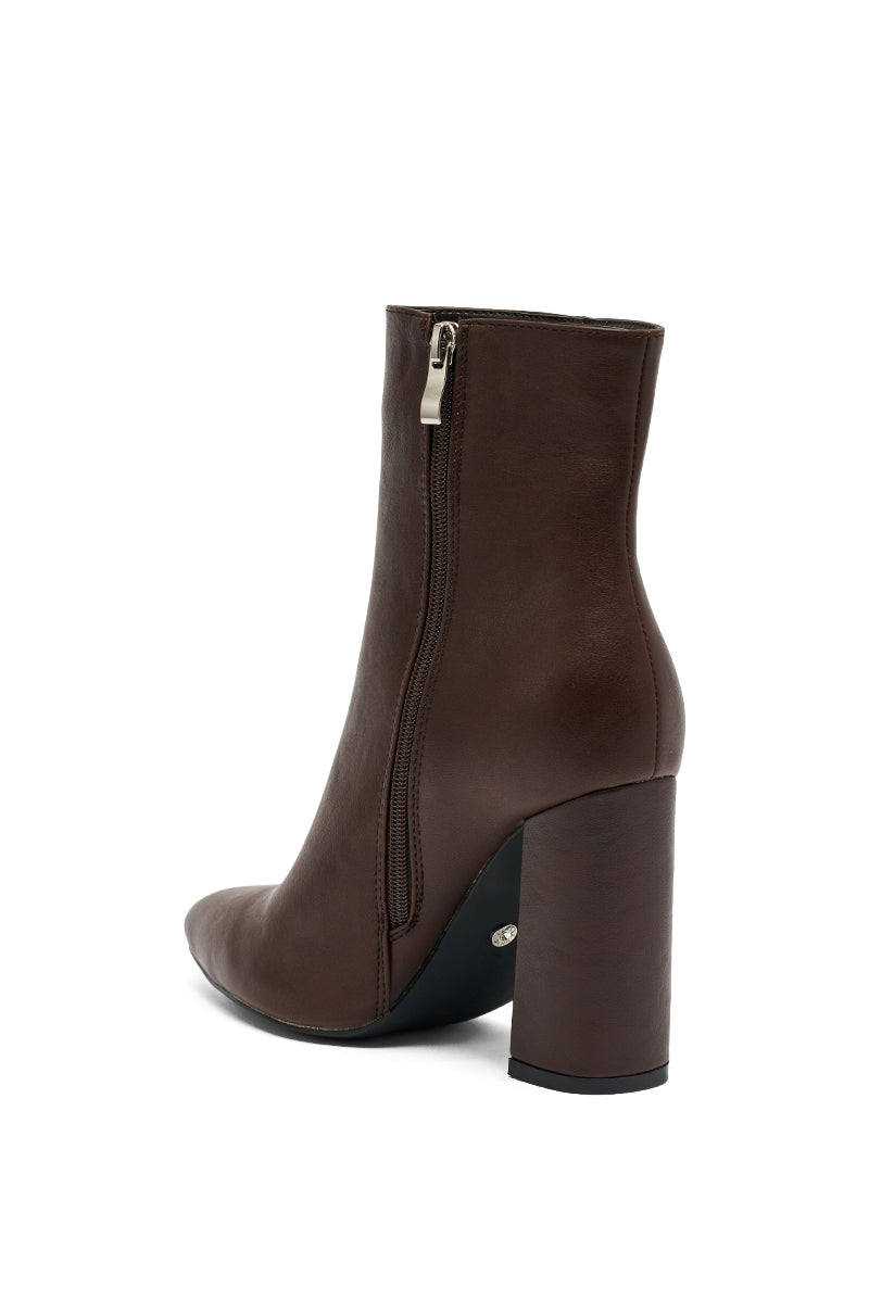 The AZALEA WANG JESSABELL BROWN POINTED TOE BOOTIE features a high block heel, side zipper, and smooth leather finish, shown from a rear side angle on a white background.