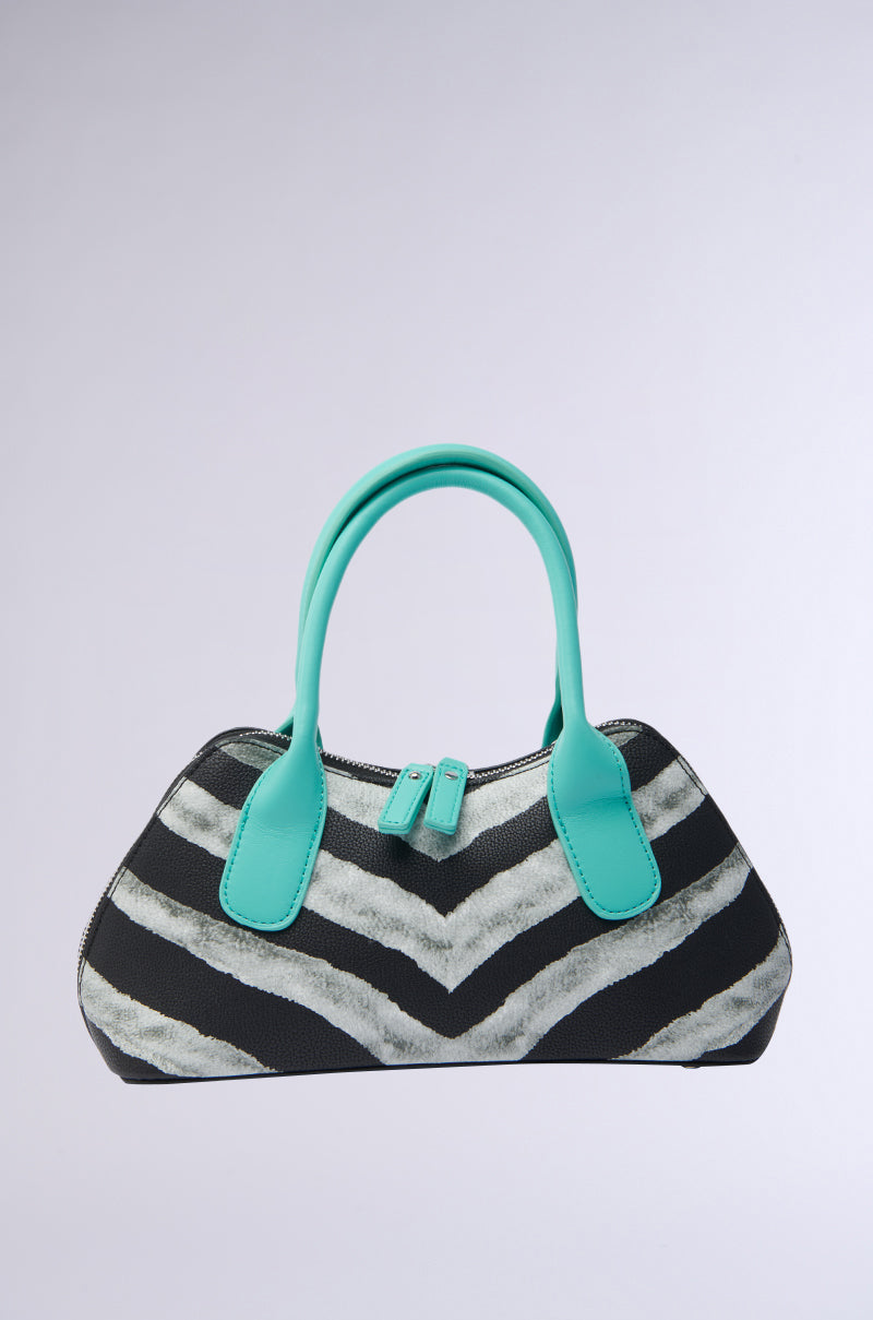 The WILD ONE ZEBRA PU PURSE features turquoise handles and a black-and-white zigzag faux leather design, shown on a plain light gray background.
