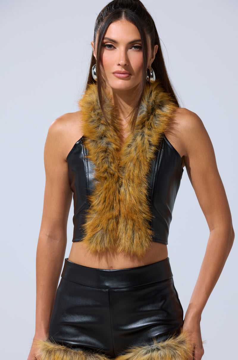A woman models the DONT TOUCH FUR BRALETTE—faux leather with brown fur trim—paired with matching shorts and hoop earrings, posing confidently against a plain background. 2