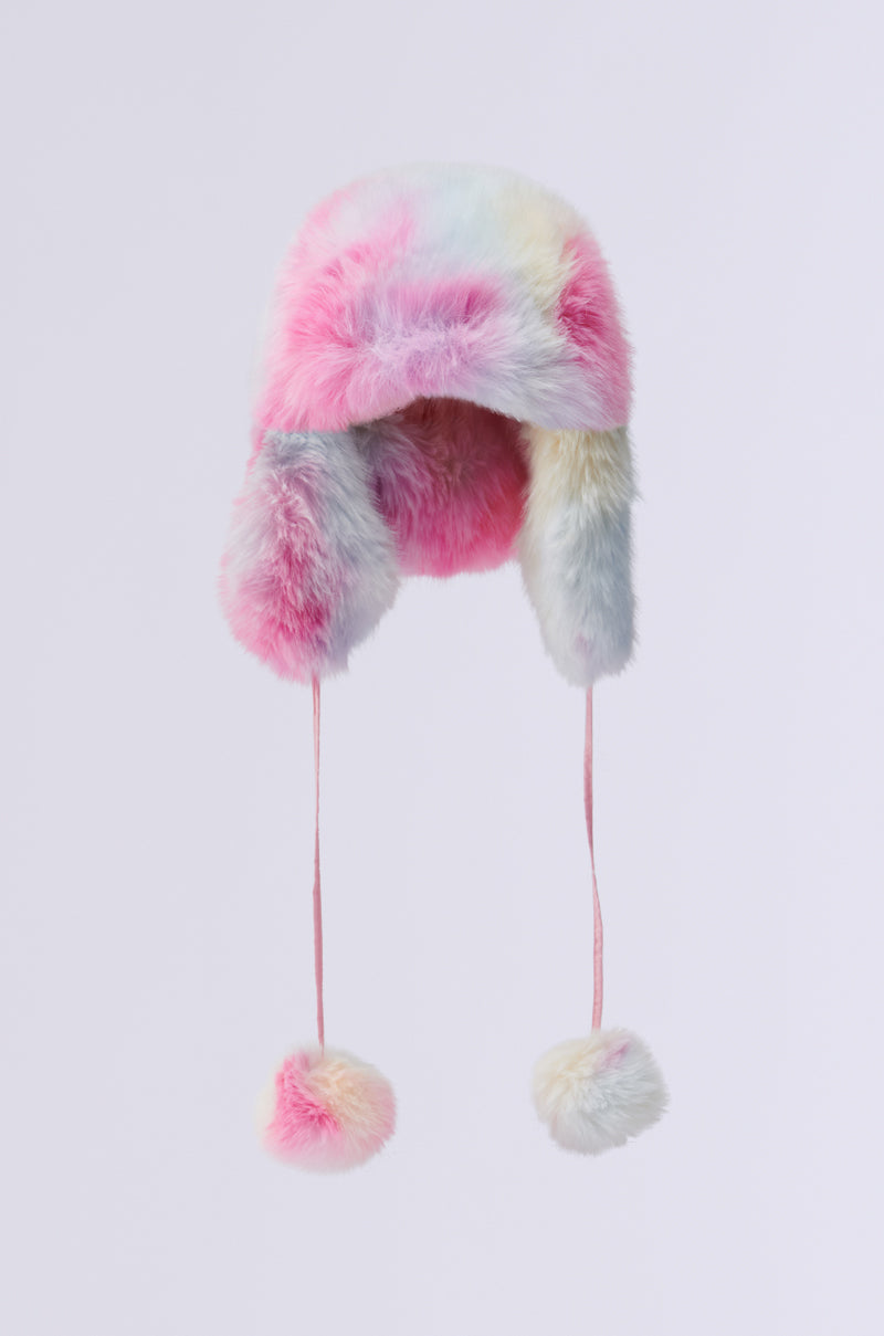 The COTTON CANDY SKIES FAUX FUR AVIATOR HAT is a plush and vibrant winter accessory, featuring ear flaps and long strings with pom-poms, evoking the essence of a pastel rainbow. Adorned in shades of pink, blue, yellow, and white, this hat is perfect for enhancing any cold weather wardrobe.