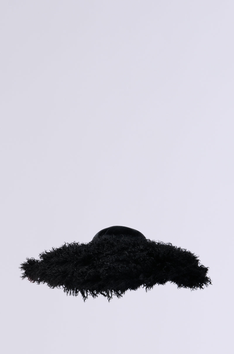 The ALWAYS ELITE FAUX FUR BRIM HAT features a textured black design with a curly, wide brim set against a simple gray backdrop. The dome-shaped crown infuses a modern, artistic touch, making it an ideal statement piece for the fashion-forward individual.