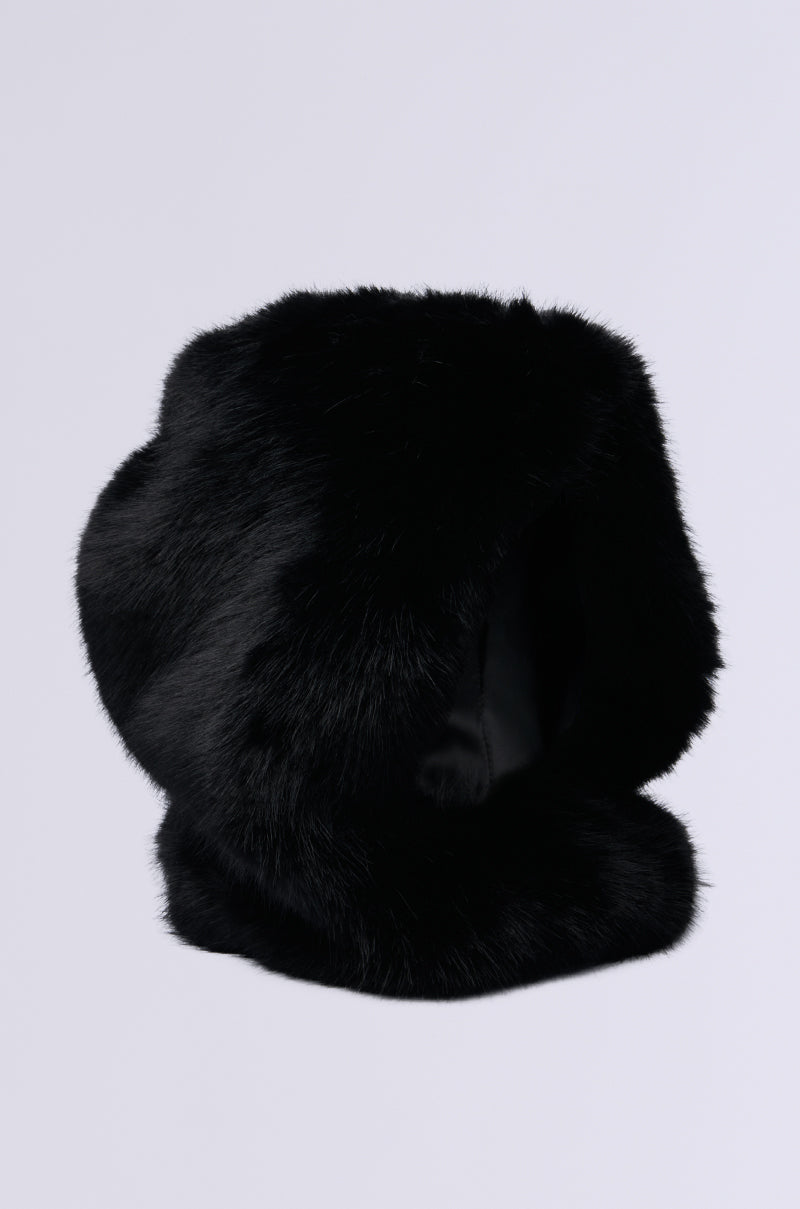 The IM THE ONE FAUX FUR HOOD, with its circular shape, soft and fluffy black texture, epitomizes luxury fashion. Set against a plain light gray background, its rich color and design make it an elegant winter accessory. 3