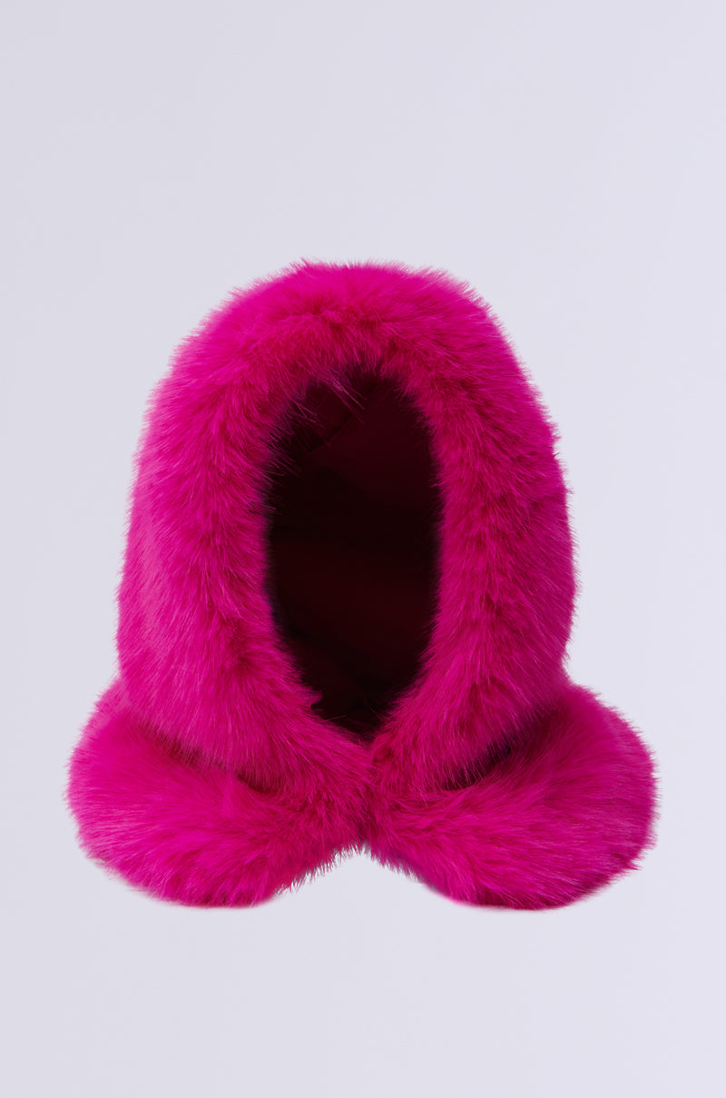 The STAND ON IT FAUX FUR HOOD, featuring an oversized design in pink faux fur, is set against a light gray background. Its plush material and fluffy appearance suggest warmth and comfort, providing an easy slip-on fit. 0