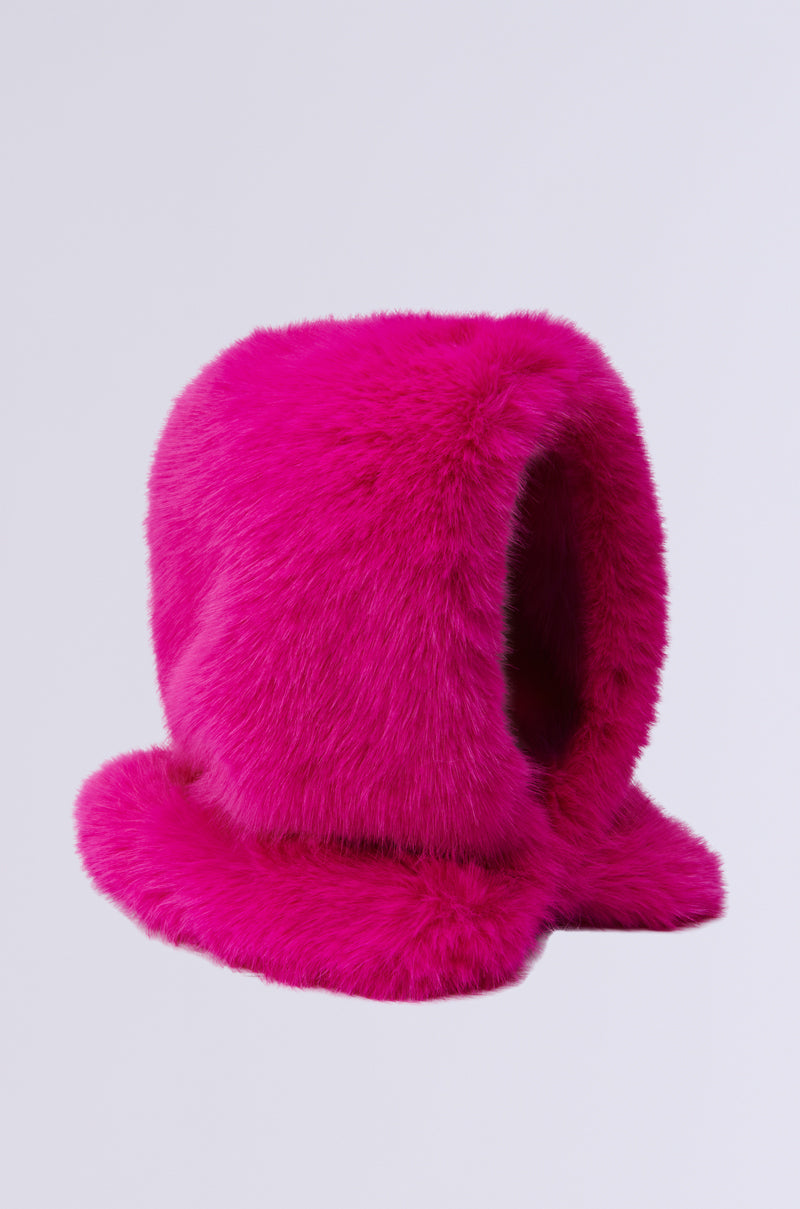 The STAND ON IT FAUX FUR HOOD is a bright pink, plush, fur-like hat featuring a slip-on fit and wide brim, showcasing its soft texture against a plain, light background. 5