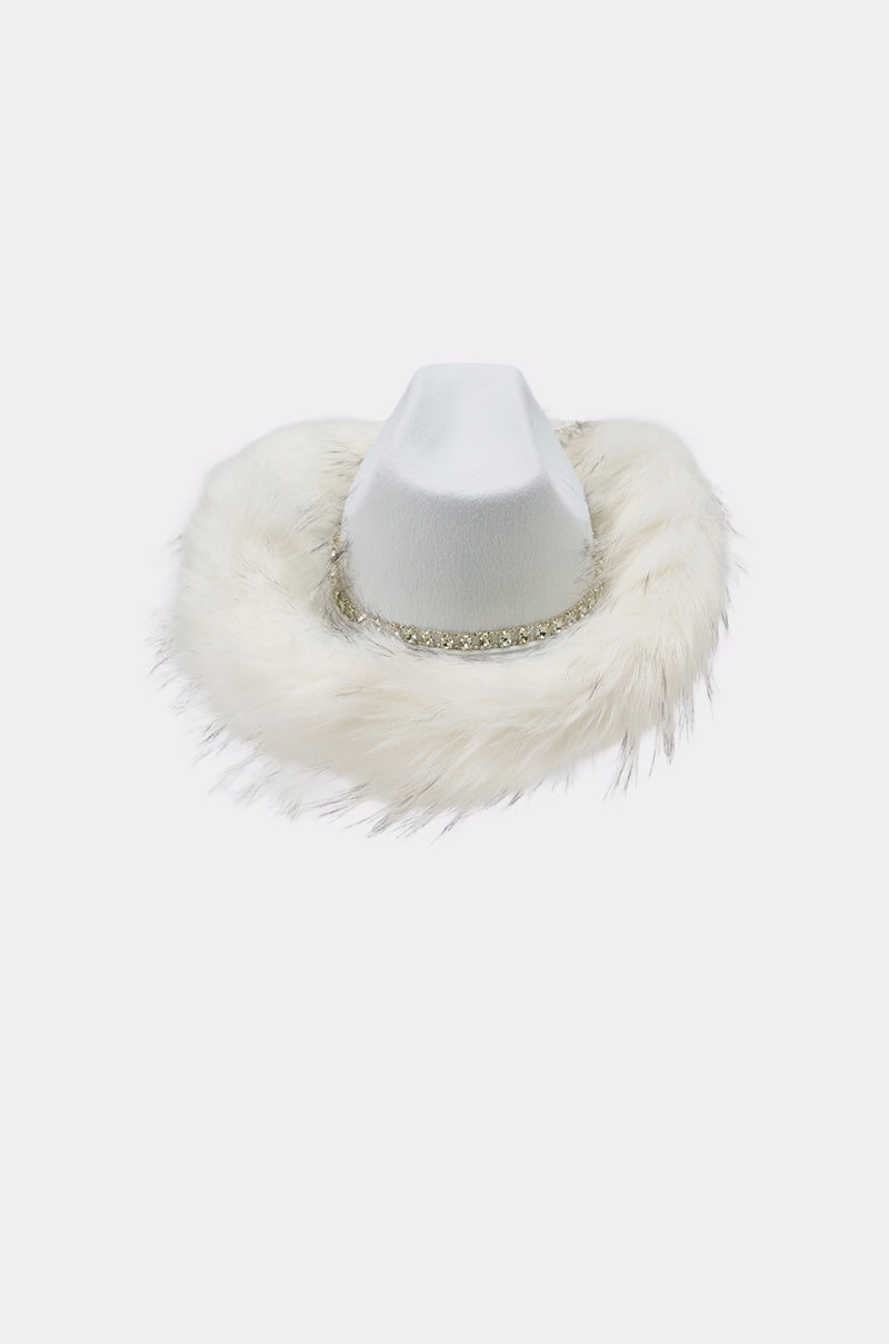The LETS RIDE FAUX FUR TRIM COWBOY HAT is a white western hat with a wide brim, cozy faux fur trim, and a sparkling rhinestone band around the crown, shown against a simple light background. 4
