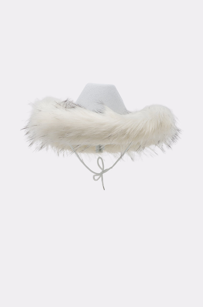 The LETS RIDE FAUX FUR TRIM COWBOY HAT features a light gray faux fur exterior, wide brim, fluffy white trim with gray streaks, and a matching chin strap tied in a bow—perfect for winter western style against any plain background. 5